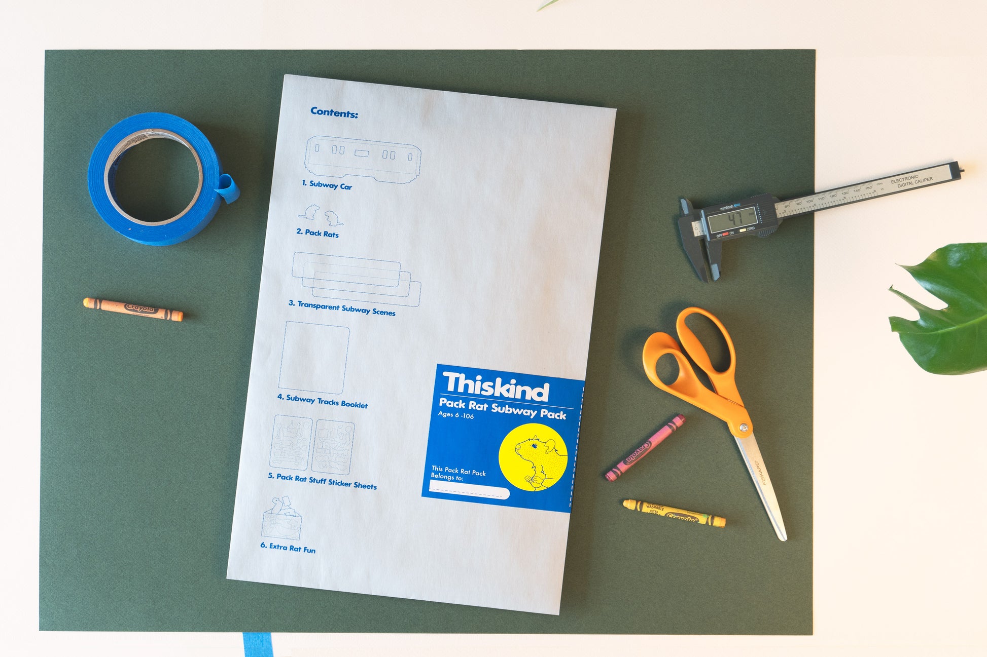 Image of Thiskind Pack Rat Subway Pack packaging. Light gray reusable paper envelope that lists contents, with blue and yellow branded label